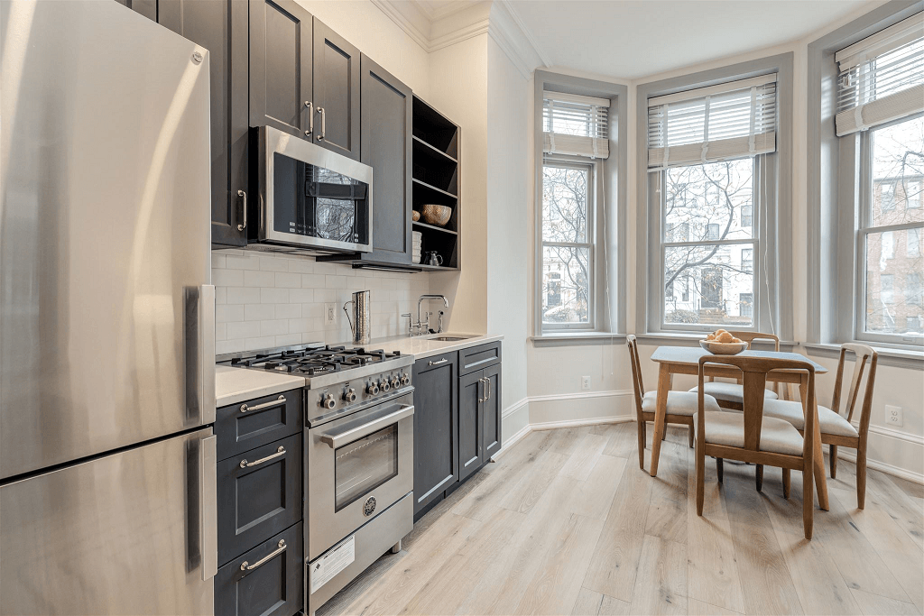 a kitchen with stainless steel appliances and a table with chairs